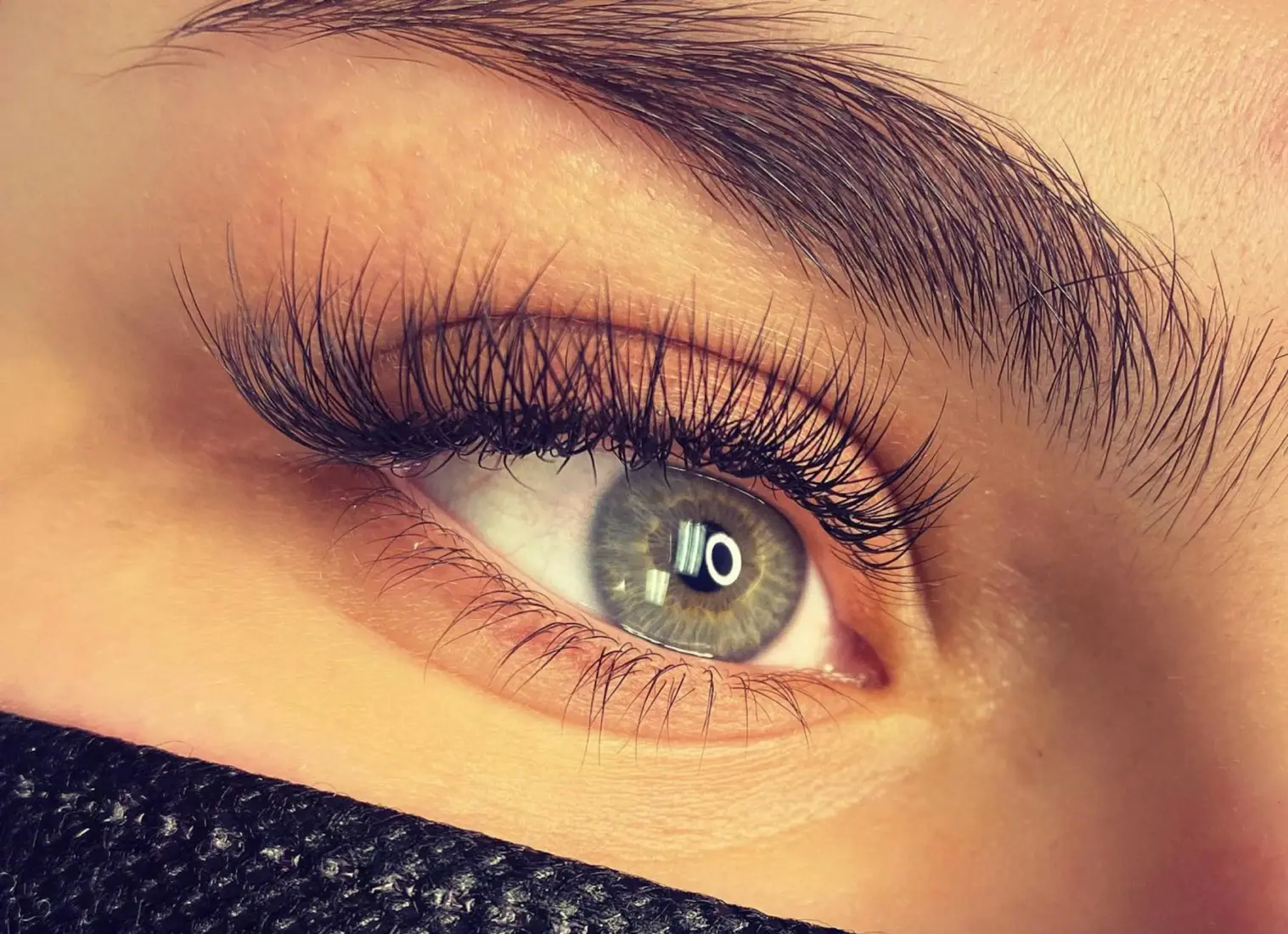 Close-up of a green eye with full, fluffy lashes