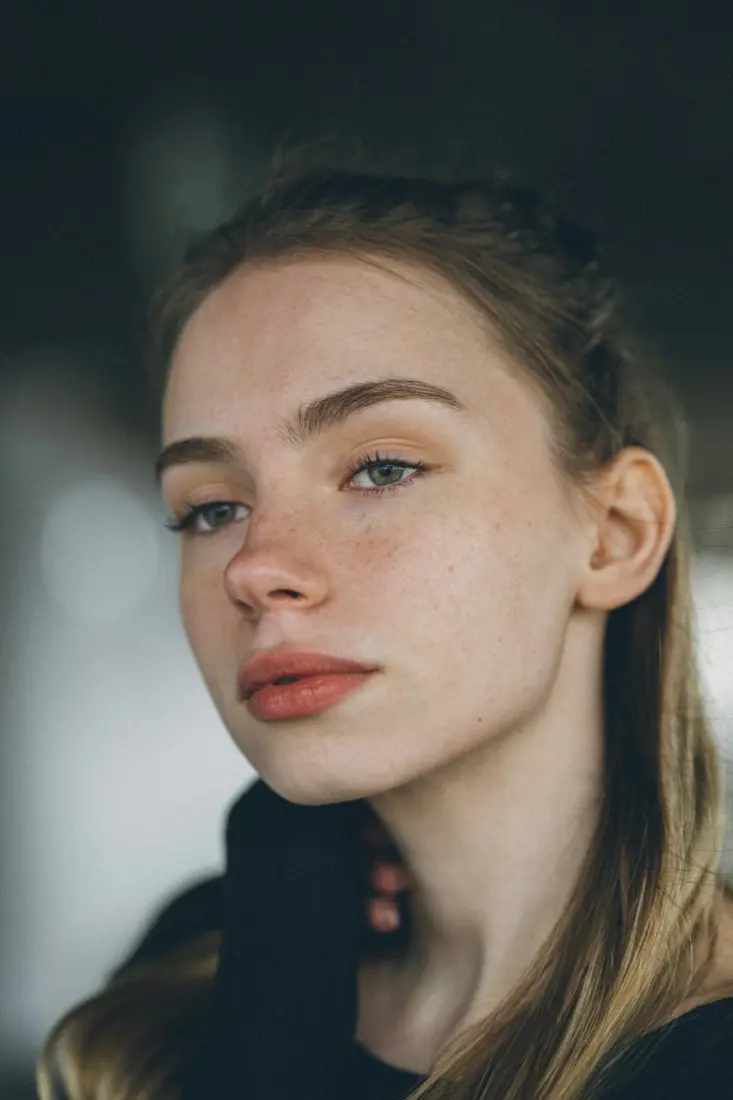 Teenage girl with freckles and clear skin looking to the side