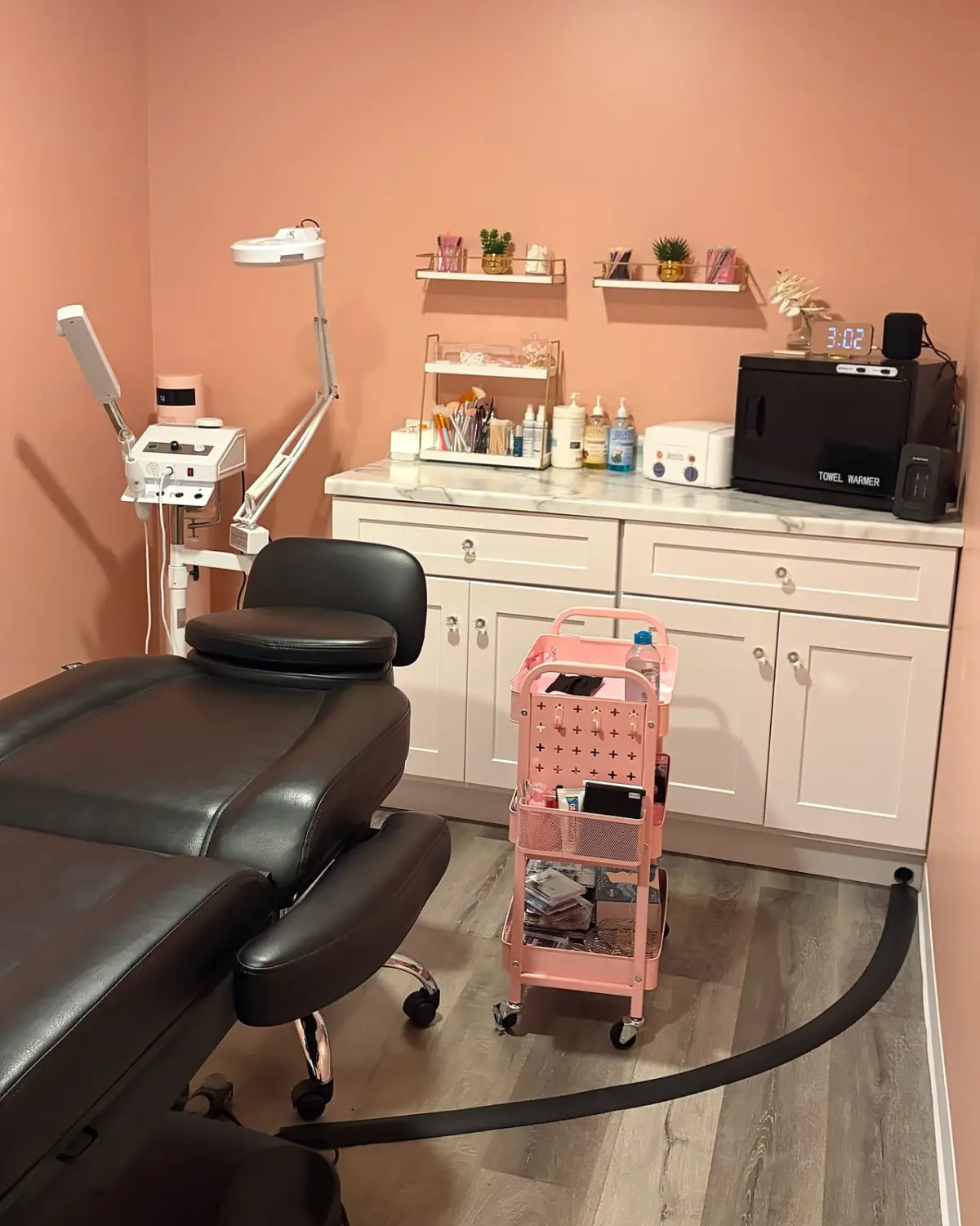 A Spathetics treatment room with the treatment chair, skin care equipment and supply cart