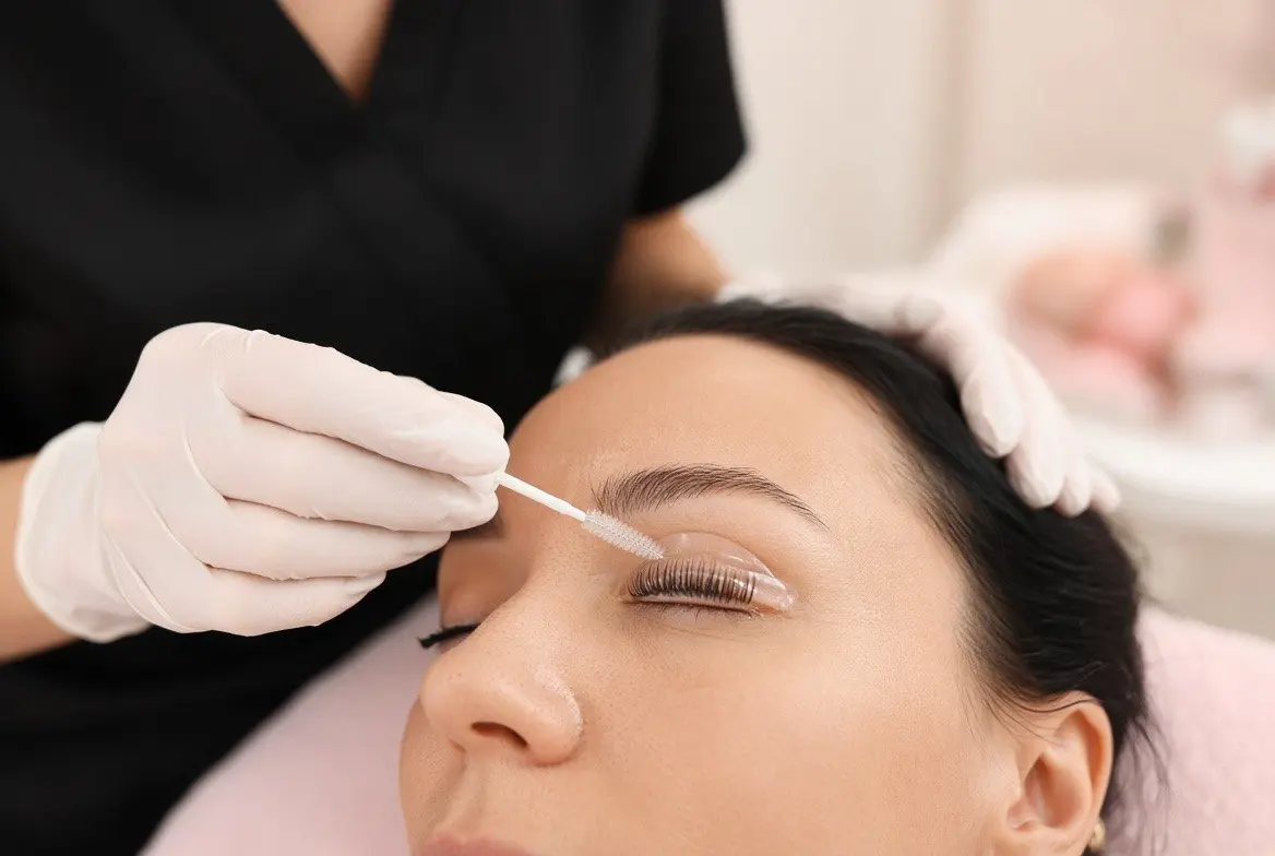 A lash lift in progress, the lashes brushed up onto a silicone shield